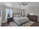 Well-lit bedroom with a king-size bed, wooden nightstands, dresser and a modern ceiling fan at 13910 Chalk Hill Pl, Riverview, FL 33579