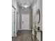 Hallway featuring sleek, laminate flooring, a decorative mirror, and a modern light fixture at 13910 Chalk Hill Pl, Riverview, FL 33579