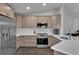 Modern kitchen boasts stainless steel appliances, white countertops, light brown cabinetry and dark wood flooring at 13910 Chalk Hill Pl, Riverview, FL 33579
