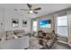 Comfortable living room with stylish seating, ceiling fan, TV, and well-lit windows with white curtains at 13910 Chalk Hill Pl, Riverview, FL 33579