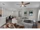 Spacious living room with lots of natural light, gray sectional sofa, wood floors and dining area in background at 13910 Chalk Hill Pl, Riverview, FL 33579