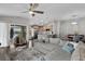 Open living space with lots of natural light, gray sectional sofa, wood floors and kitchen view in background at 13910 Chalk Hill Pl, Riverview, FL 33579