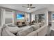 Inviting living room with comfortable seating, ceiling fan, TV, and sliding glass doors to outdoor space at 13910 Chalk Hill Pl, Riverview, FL 33579
