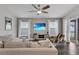 Inviting living room featuring plush seating, ceiling fan, TV, and sliding glass doors to the outdoors at 13910 Chalk Hill Pl, Riverview, FL 33579