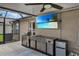 Outdoor kitchen with stainless steel appliances, a built-in grill, and a bar area overlooking the pool at 13910 Chalk Hill Pl, Riverview, FL 33579