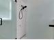Walk-in shower with frameless glass doors, mosaic tile floor, and black shower head and hardware at 13910 Chalk Hill Pl, Riverview, FL 33579