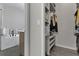 Bright walk-in closet featuring custom shelving with organized storage solutions and neutral color palette at 13910 Chalk Hill Pl, Riverview, FL 33579
