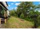 Landscaped backyard featuring green grass and trees offers space for outdoor activities at 1395 White Fox Run, Lutz, FL 33549