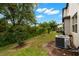 Home backyard with a modern air conditioning unit and mature trees at 1395 White Fox Run, Lutz, FL 33549