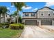 This is an exterior view of a modern home featuring a two-car garage and well-maintained landscaping at 1395 White Fox Run, Lutz, FL 33549