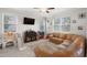 Comfortable living room with large sectional sofa, lots of natural light, and wall-mounted TV at 1395 White Fox Run, Lutz, FL 33549