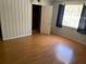 Bedroom featuring durable laminate wood flooring, vertical paneling and large window with curtains at 15034 Lake Magdalene Blvd, Tampa, FL 33618