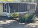 Exterior view of home with screened porch and landscaping at 15034 Lake Magdalene Blvd, Tampa, FL 33618