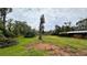 Large, grassy backyard featuring mature trees and garden beds on a spacious lot at 19036 Blake Rd, Odessa, FL 33556