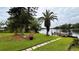 Beautiful waterfront view with a dock, lush greenery, and a paver walkway to the water at 19036 Blake Rd, Odessa, FL 33556