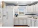 Bright kitchen with white appliances and custom cabinets at 213 Fernwood Cir # 213, Seminole, FL 33777