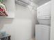 Efficient laundry area with stacked washer and dryer, along with shelving for organized storage at 213 Fernwood Cir # 213, Seminole, FL 33777