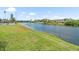 Scenic waterfront view of a lake bordered by lush green grass and beautiful homes at 213 Fernwood Cir # 213, Seminole, FL 33777