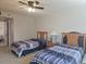 Bright bedroom featuring two beds and a ceiling fan at 2333 Feather Sound Dr # A401, Clearwater, FL 33762