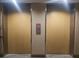 Image of a pair of elevators with wood paneled doors and illuminated floor indicators at 2333 Feather Sound Dr # A401, Clearwater, FL 33762