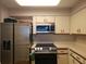 A bright kitchen features white cabinets, countertops and stainless steel appliances at 2333 Feather Sound Dr # A401, Clearwater, FL 33762