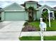 Charming single-story home with a well-manicured lawn, palm trees, and a two-car garage, all painted in a welcoming green hue at 2511 Indian Key Dr, Holiday, FL 34691