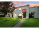 Charming townhouse featuring a well-manicured lawn and unique red awning detail over the front door at 2834 Somerset Park Dr, Tampa, FL 33613