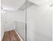 Upstairs hallway features updated flooring, a metal railing, and a closet for additional storage at 2834 Somerset Park Dr, Tampa, FL 33613
