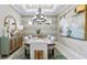 Dining room with chandelier, light grey walls, large windows and decorative painting at 29472 Velletri Ln, Wesley Chapel, FL 33543