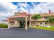 Front of the clubhouse featuring an American flag, covered entrance, and tropical landscaping at 3018 59Th S St # 209, Gulfport, FL 33707