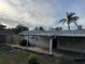 Wide view of the backyard with a green lawn, fenced perimeter and a covered patio at 3118 Adrian Ave, Largo, FL 33774