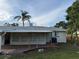 View of the back of the home with a covered patio and large backyard at 3118 Adrian Ave, Largo, FL 33774