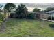Large backyard with a green lawn, wood fence and shady trees in the rear at 3118 Adrian Ave, Largo, FL 33774