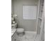 Bathroom with a white toilet, open shelving, and marble-like tile floors at 3118 Adrian Ave, Largo, FL 33774