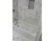 Bright bathroom featuring a marble-tiled wall, a bathtub, and a built-in niche at 3118 Adrian Ave, Largo, FL 33774
