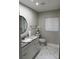 Bathroom with marble floors, granite countertops, and a round mirror at 3118 Adrian Ave, Largo, FL 33774