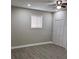 A bedroom features gray flooring, light gray walls, ceiling fan, and a window at 3118 Adrian Ave, Largo, FL 33774