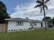 Charming single-story home with a well-maintained lawn, a palm tree and a driveway at 3118 Adrian Ave, Largo, FL 33774