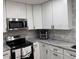 Bright kitchen features stainless steel appliances, white cabinets, and granite countertops at 3118 Adrian Ave, Largo, FL 33774