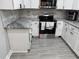 Modern kitchen features white cabinets, stainless steel appliances, and granite countertops at 3118 Adrian Ave, Largo, FL 33774
