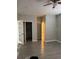 Open room with white trim, gray flooring, and light gray walls with multiple doors at 3118 Adrian Ave, Largo, FL 33774