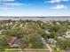 Scenic aerial view shows a cozy neighborhood with trees and houses near a large body of water at 320 Broadway, Dunedin, FL 34698