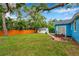 Lush backyard featuring a private wood fence, mature trees, and well-maintained lawn at 320 Broadway, Dunedin, FL 34698