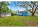 Charming home with a spacious backyard, lush lawn, mature trees, and a detached garage at 320 Broadway, Dunedin, FL 34698