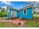 Cozy backyard patio features brick accents and a quaint seating area, perfect for relaxing outdoors at 320 Broadway, Dunedin, FL 34698