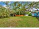 Expansive backyard featuring green grass, mature trees, and a private wood fence at 320 Broadway, Dunedin, FL 34698