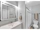 Well-lit bathroom with vanity, large mirror, and shower-tub combination with white tile at 320 Broadway, Dunedin, FL 34698