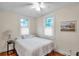 Cozy bedroom features natural light from dual windows and classic hardwood floors at 320 Broadway, Dunedin, FL 34698