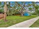 Charming blue cottage with a lush lawn and mature trees in a desirable neighborhood at 320 Broadway, Dunedin, FL 34698