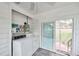 Bright laundry room featuring appliances, tile floor, and natural light with sliding glass doors at 320 Broadway, Dunedin, FL 34698